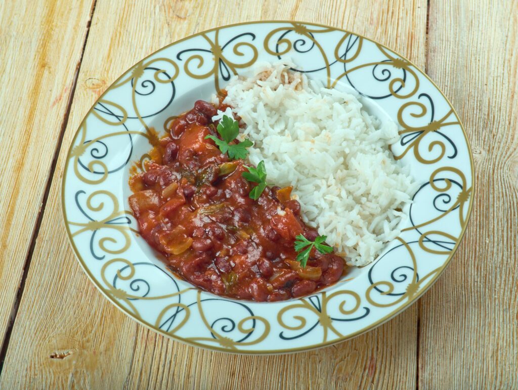 a bowl of Fasoulya with white rice on a wooden table